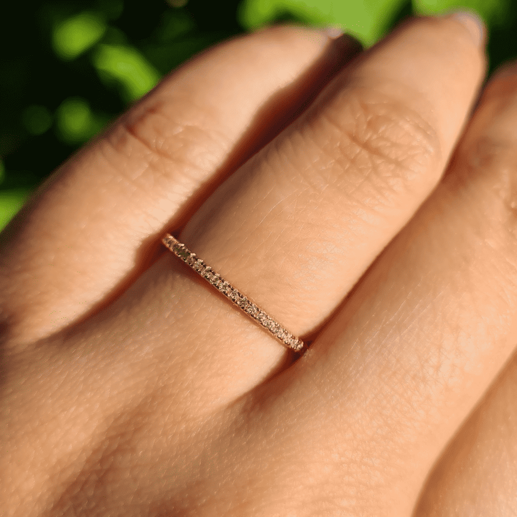 Thin rose gold eternity ring on a finger