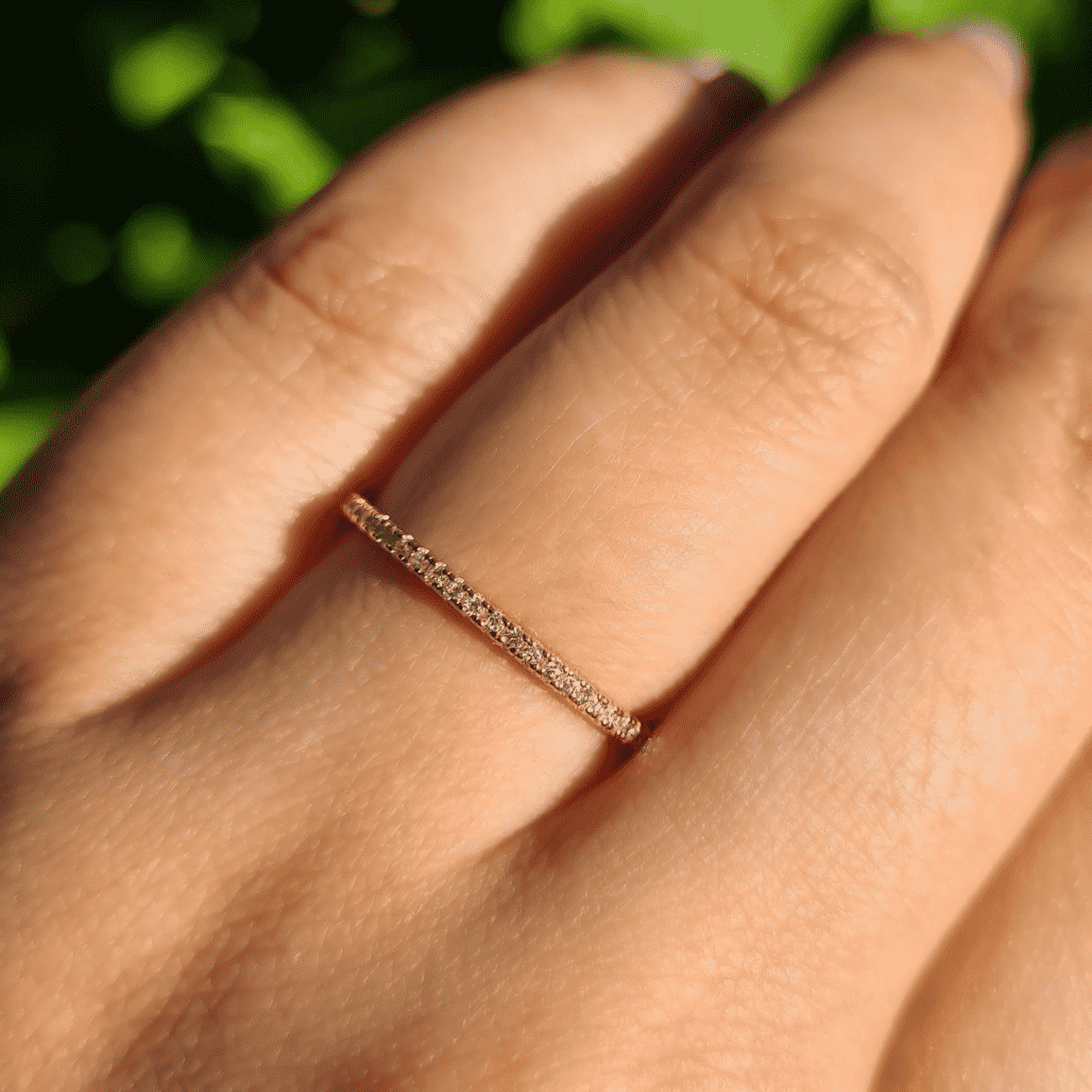 Thin rose gold eternity ring on a finger