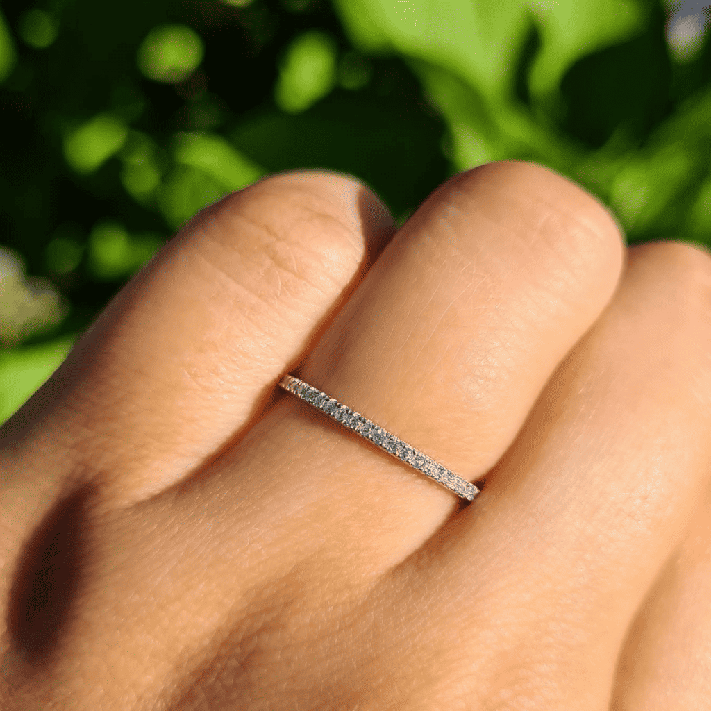 Thin sterling silver eternity ring with pavé stones on a finger