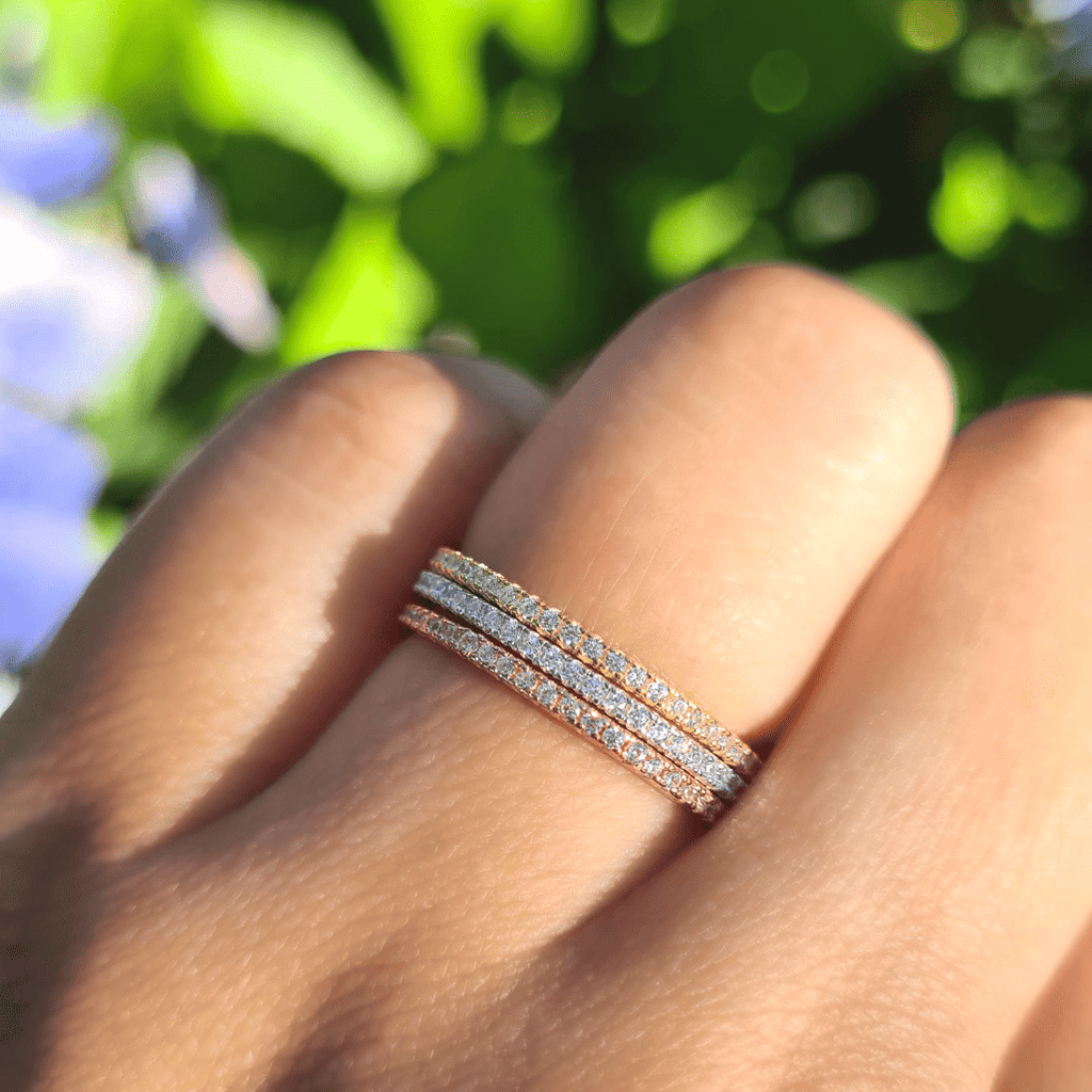 Three slim diamond eternity stacking rings on a finger