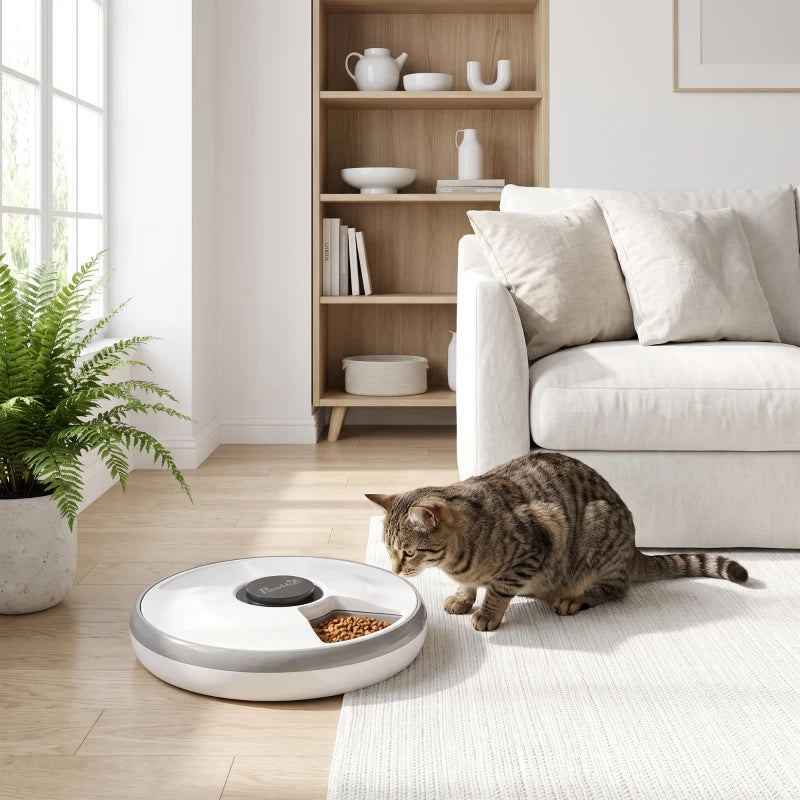 Grey automatic cat feeder with a tabby cat eating from the bowl