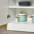 White cabinet interior corner with door hinge hardware and top shelf surface