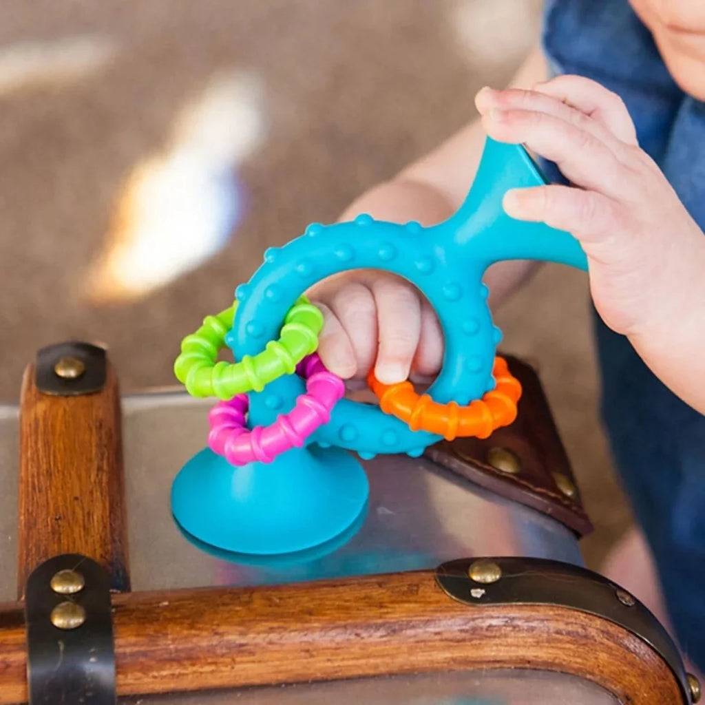Teal loop teether with colorful squiggle links, held by an adult