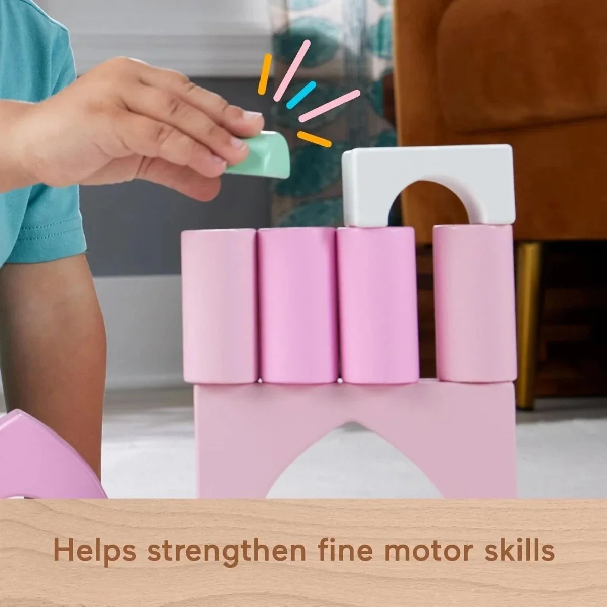 Pastel pink wooden castle blocks with a hand placing a teal block on top