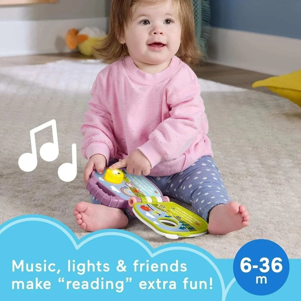 Child holding purple Fisher-Price musical storybook toy with sun and monkey design