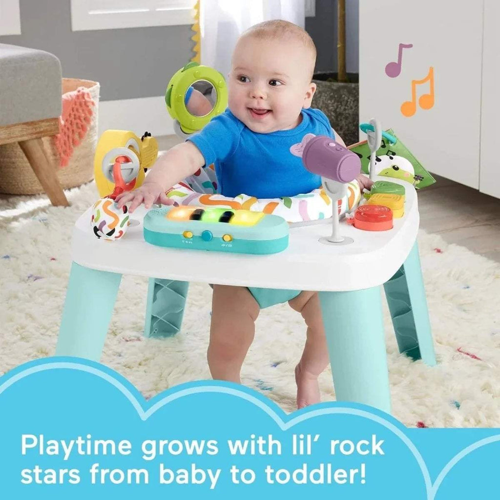 Infant seated at a white activity table with teal legs and colorful piano-style panel