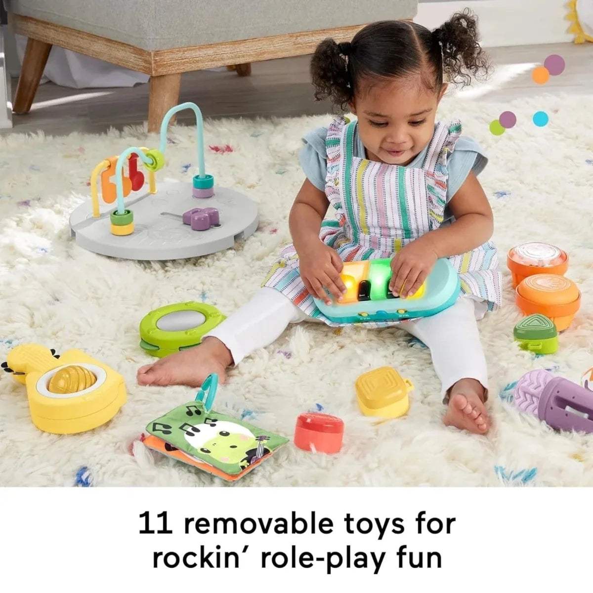 Toddler playing with a music activity table and scattered removable toys on the floor
