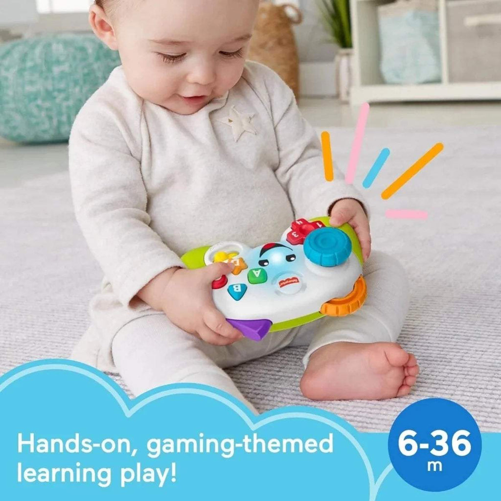 Kids learning game controller held by baby, green body with purple and blue button panel