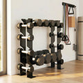 Black 4-tier dumbbell rack with tiered pegs and weights, standing against wall