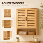 Oak bathroom wall cabinet with louvered double doors and open lower storage