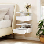 White floating bedside table with open shelves and drawer, styled beside a sofa