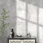 Silver round wall mirror with abstract metal wire loop frame on a wall