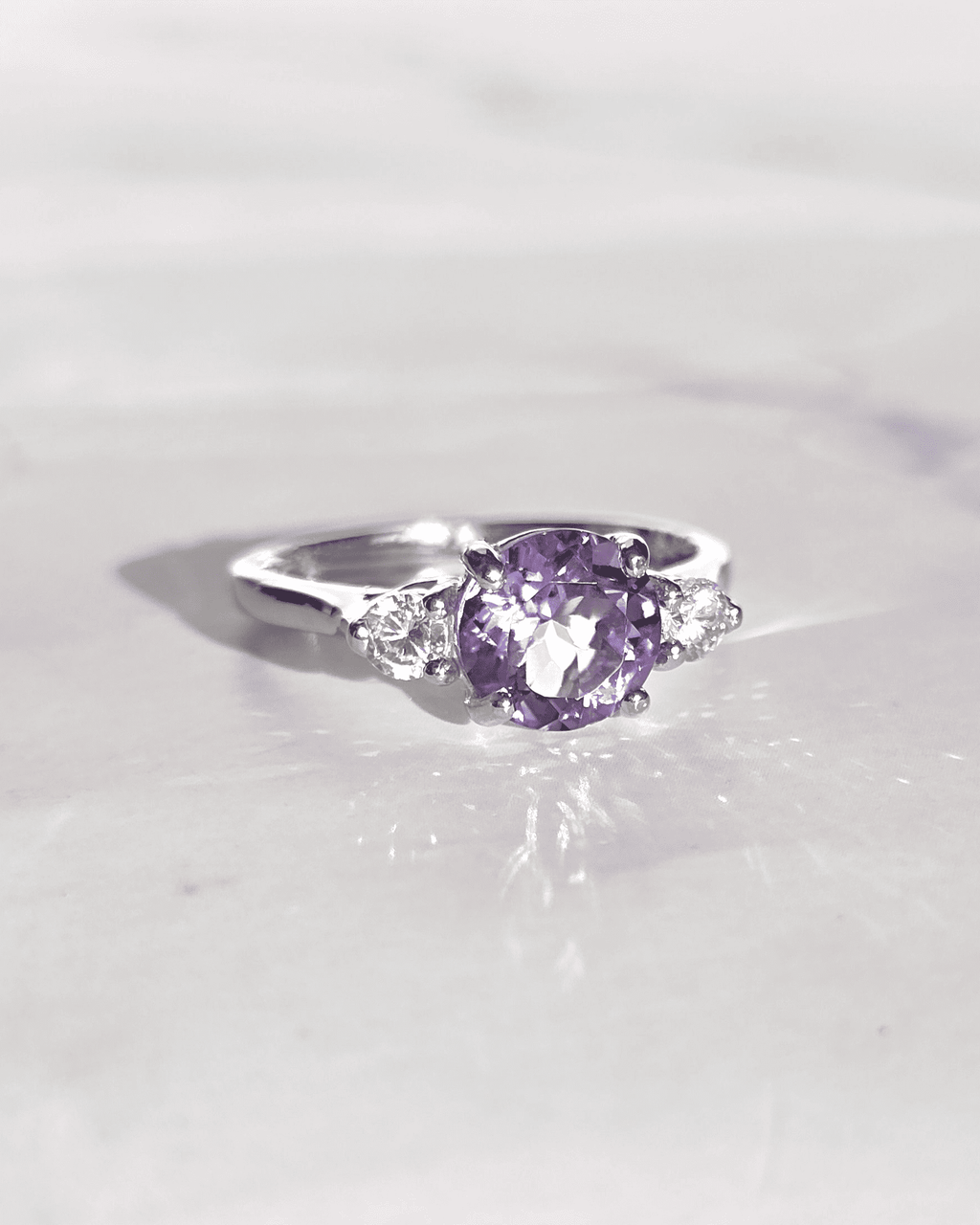 Three-stone amethyst ring in sterling silver with purple oval center and side stones