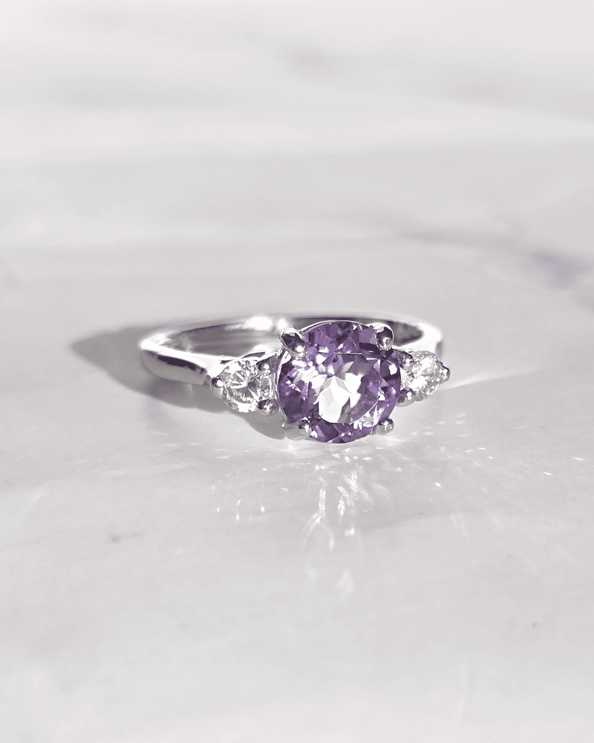 Three-stone amethyst ring in sterling silver with purple oval center and side stones