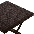 Close-up of brown woven rattan tabletop with folding X-frame base