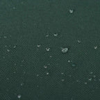 Close-up of green textured oxford fabric with visible water droplets beading on surface.