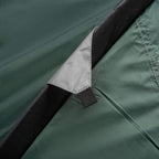 Green tent panel with black trim and strap attachment detail