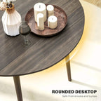 Grey round tabletop of a drop-leaf dining table with wood legs, candles on top
