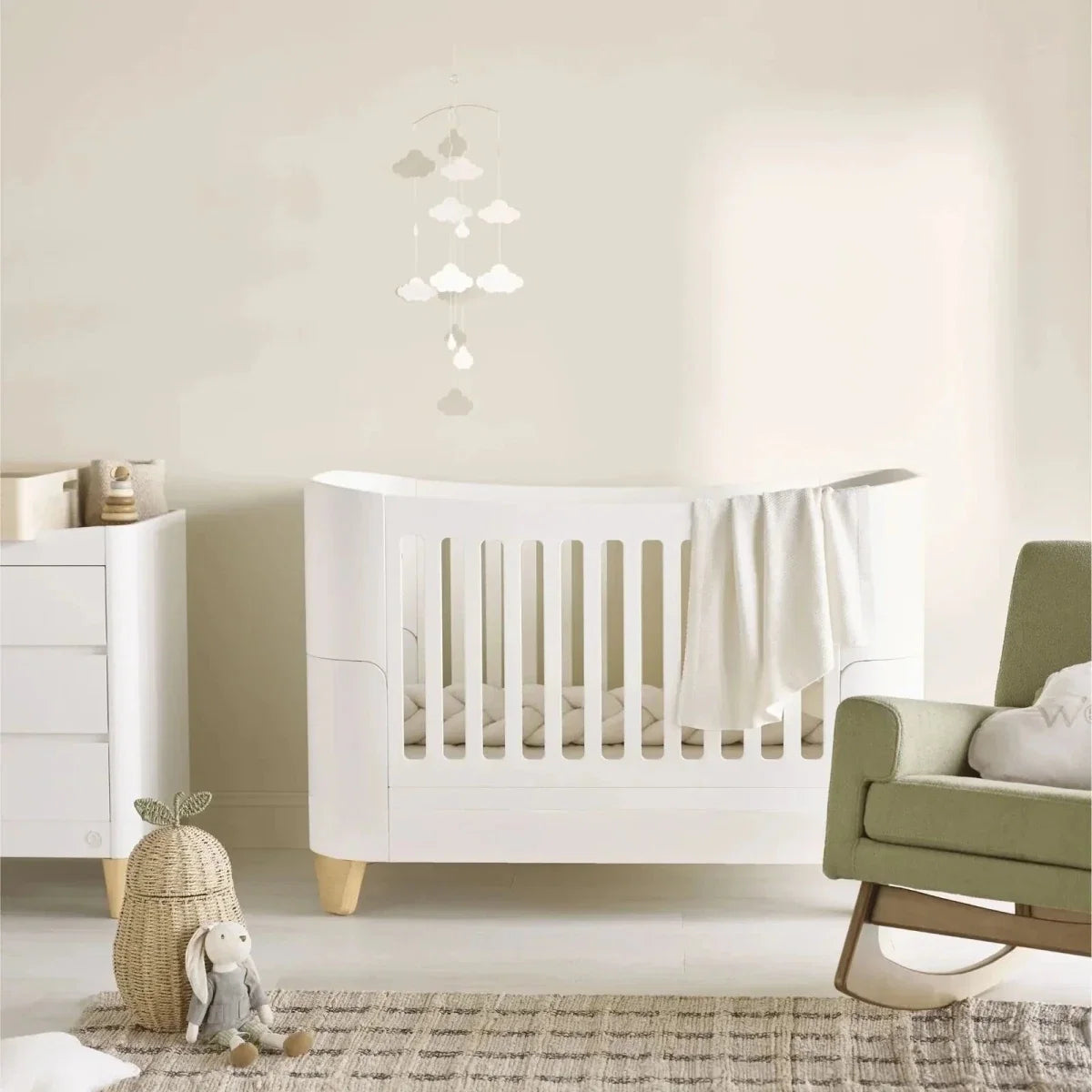 White cot bed and bedside crib with slatted rails and short natural wood legs
