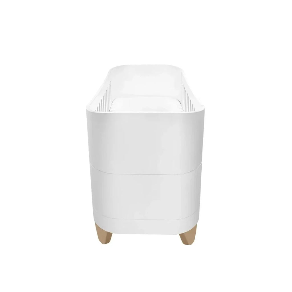 White bedside crib frame with rounded top panels and short safety sides