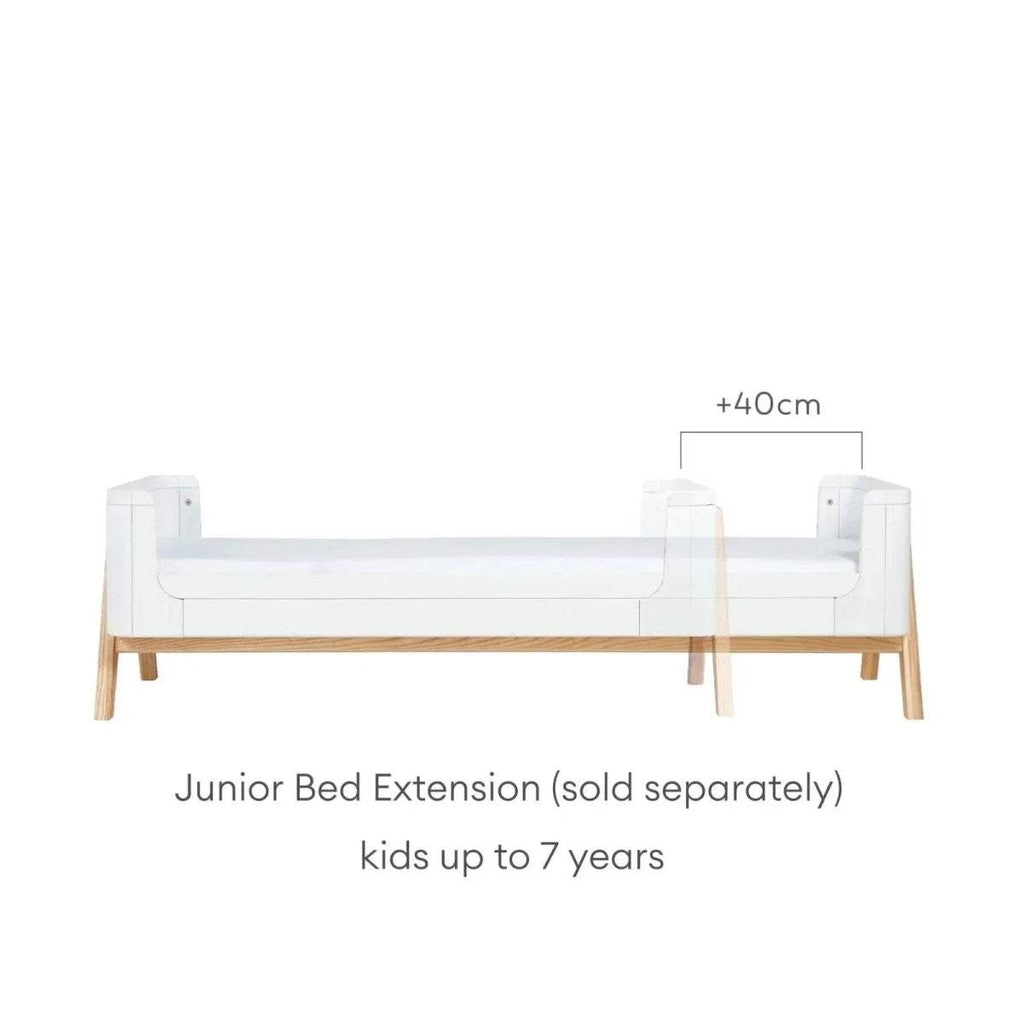 Convertible junior bed extension with white rails and natural wood legs