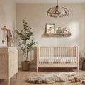 Natural ash baby crib with vertical slat sides and white mattress