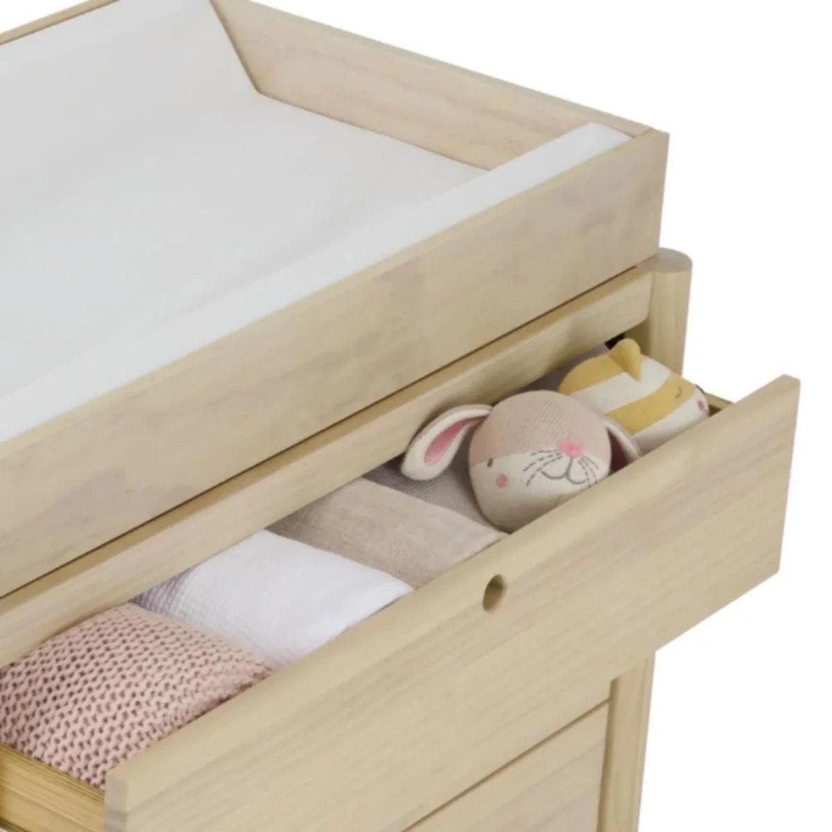 Natural ash crib base with open under-bed storage and plush toys