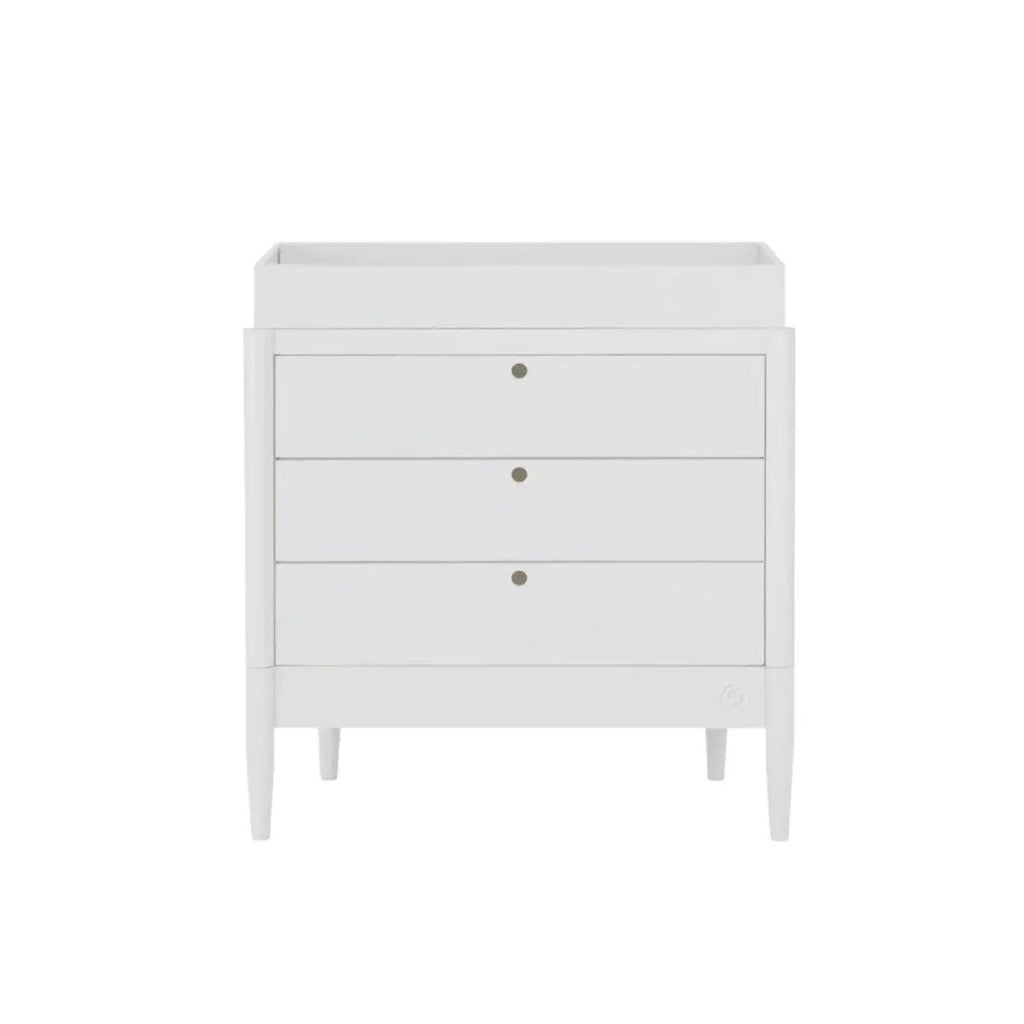 White baby dresser with three drawers and gold-tone knobs, raised legs