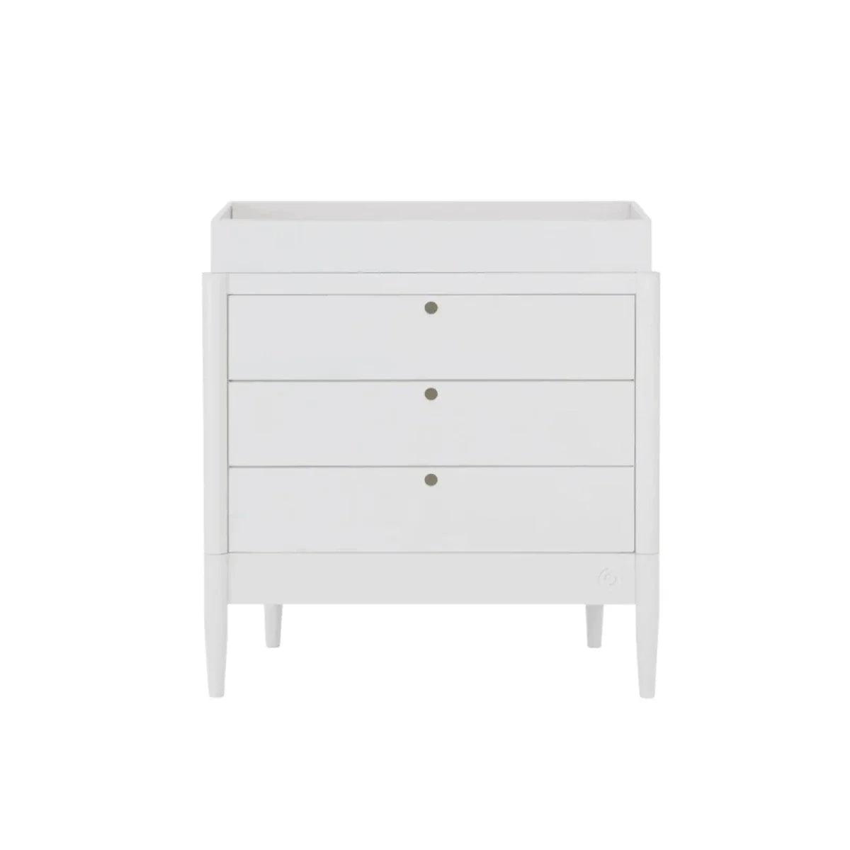 White baby dresser with three drawers and gold-tone knobs, raised legs