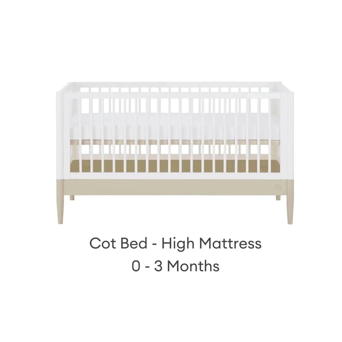 White cot bed frame with high mattress position and light wood legs