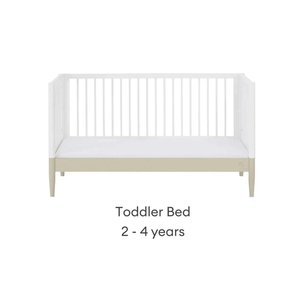 White toddler bed frame with front rail and light wood legs