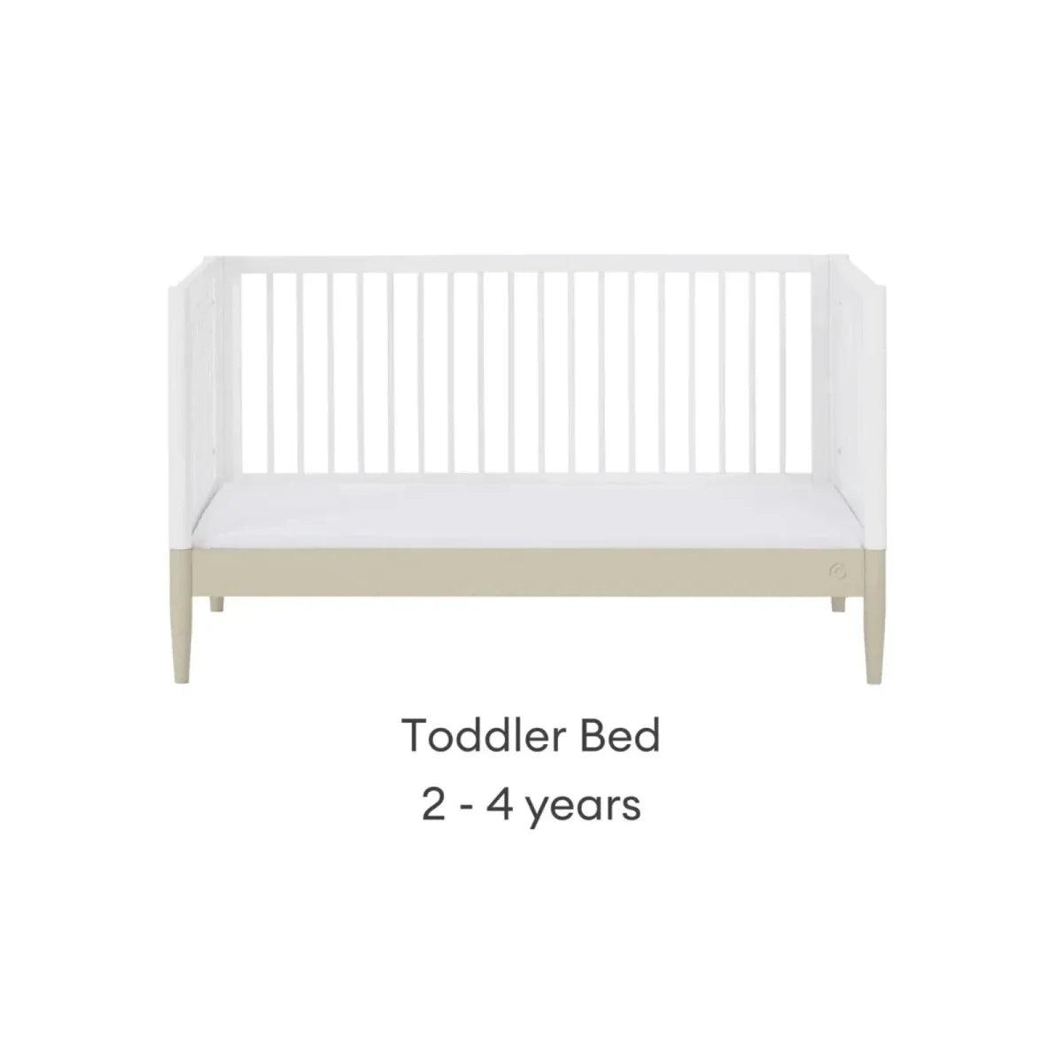 White toddler bed frame with front rail and light wood legs