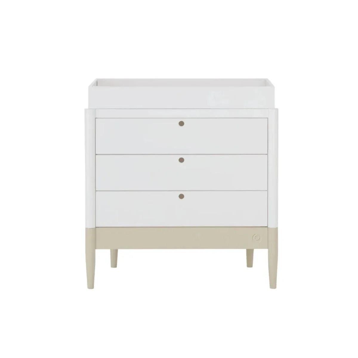 White baby dresser with three drawers, round knobs, and desert sage base strip