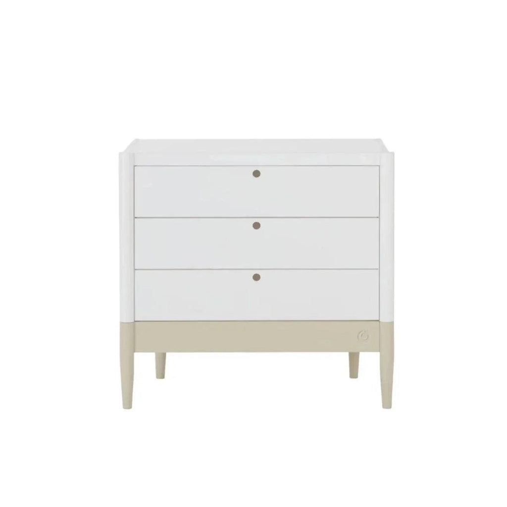 White baby dresser front with three drawers, round knobs, and desert sage base strip