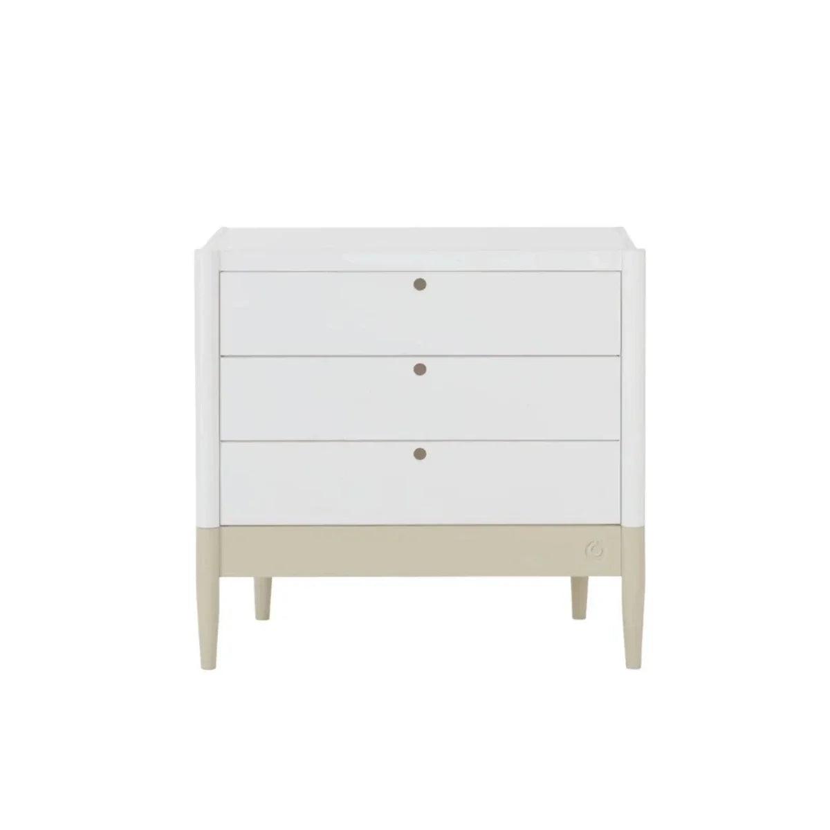 White baby dresser front with three drawers, round knobs, and desert sage base strip