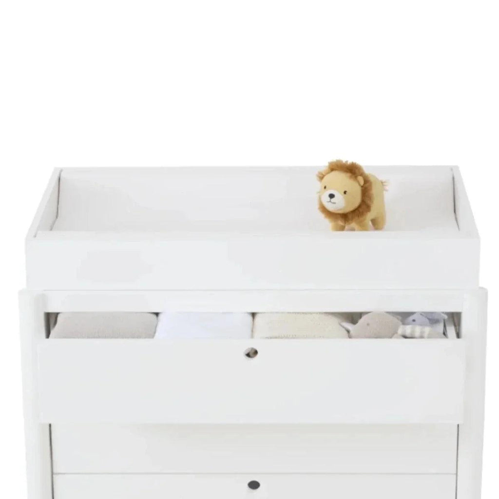 White baby crib with raised side rail, desert sage band, and plush lion on bedding