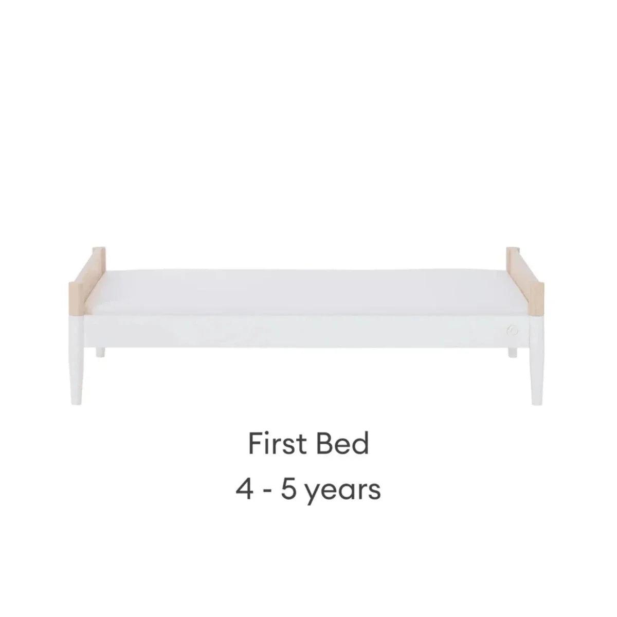 First bed with natural ash end panels and white mattress, low guard profile