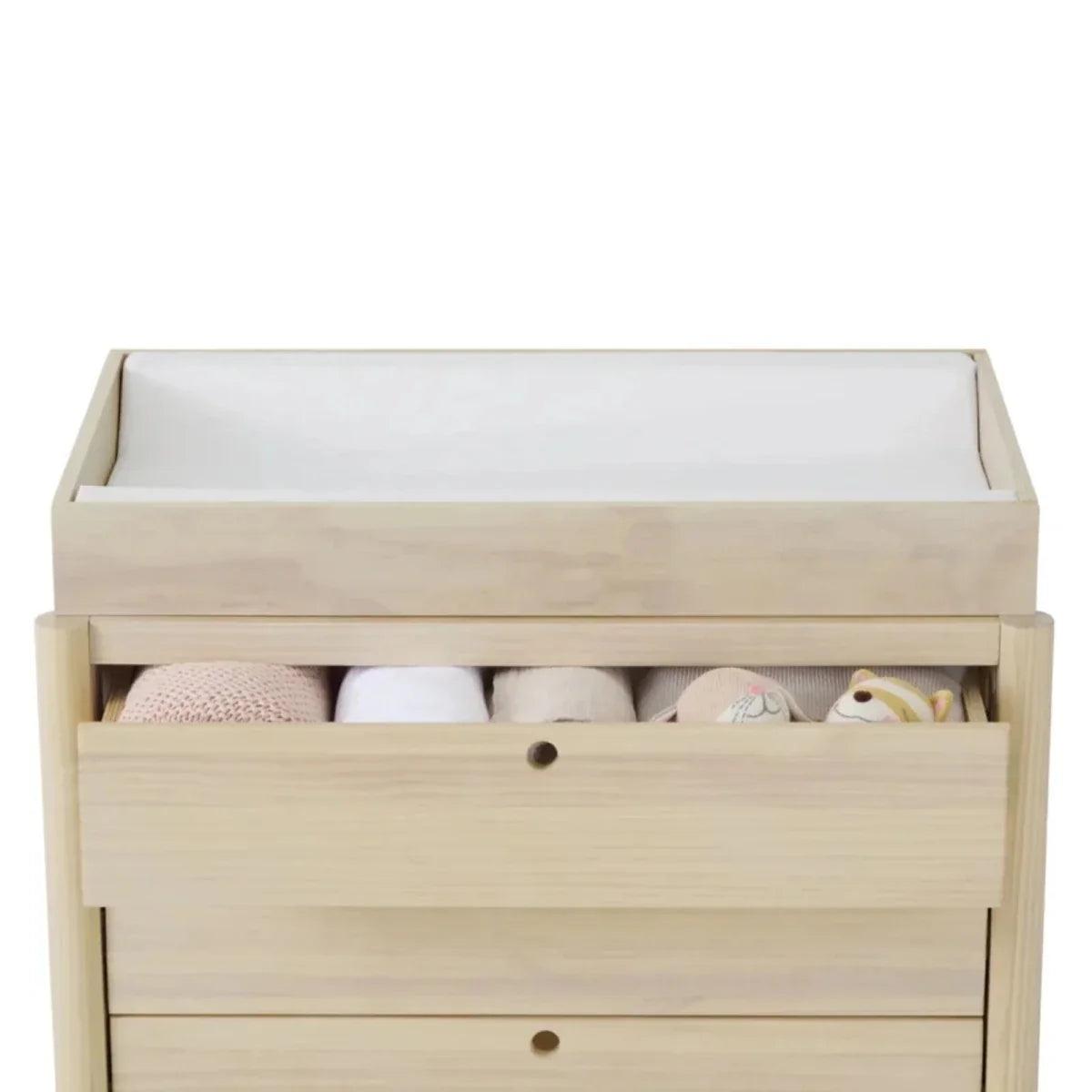 Wooden baby crib with open drawer storage and visible bedding, natural ash