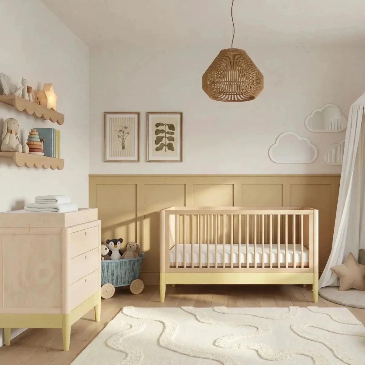 Baby room set with light wood cot bed and matching white dresser in primrose yellow