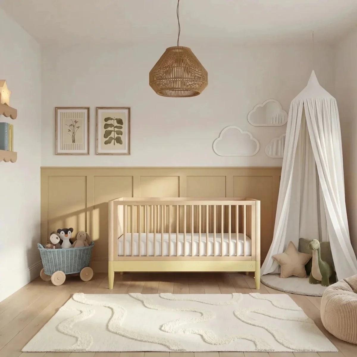 Baby room set featuring a light wood cot bed with white canopy and soft yellow accents