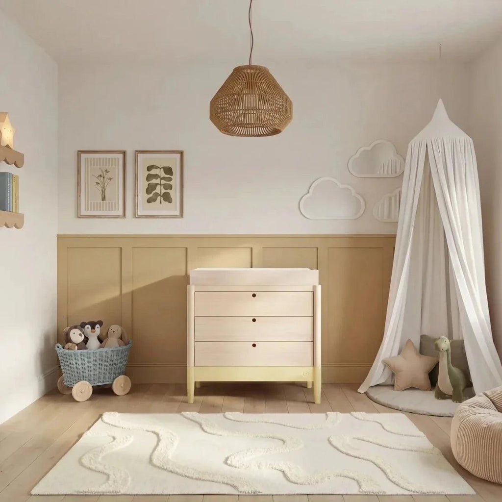 Baby room set with light wood cot bed and white dresser, styled with neutral decor