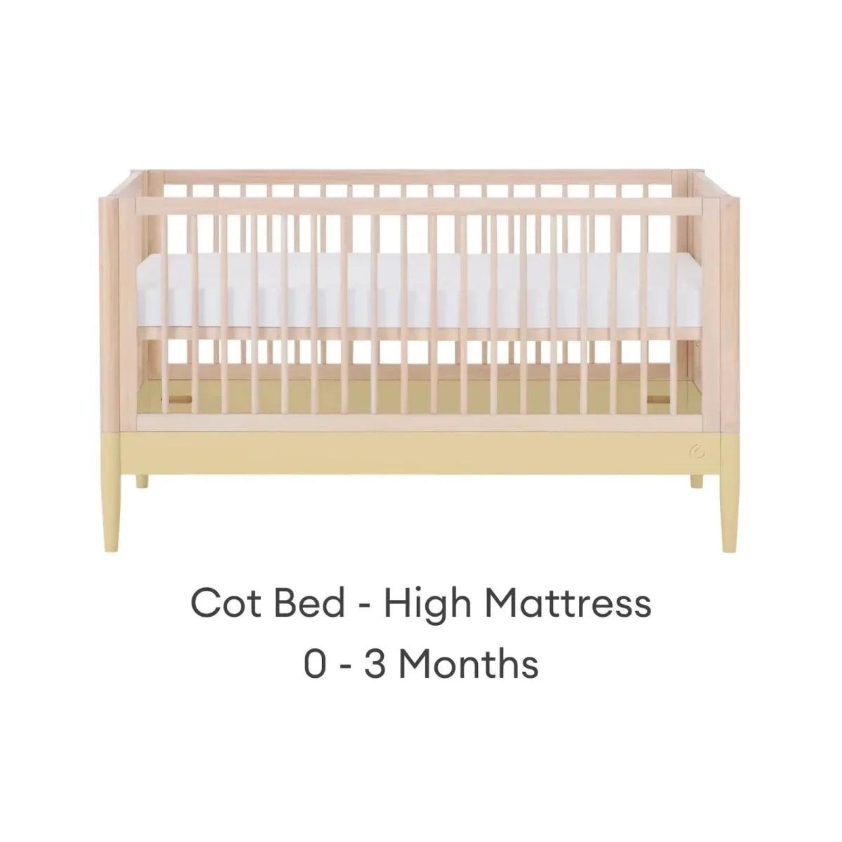 Cot bed with high mattress level, light wood frame and white mattress panel
