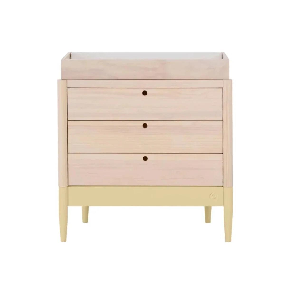 Wood baby dresser with three drawers, round knob pulls, and pale yellow base