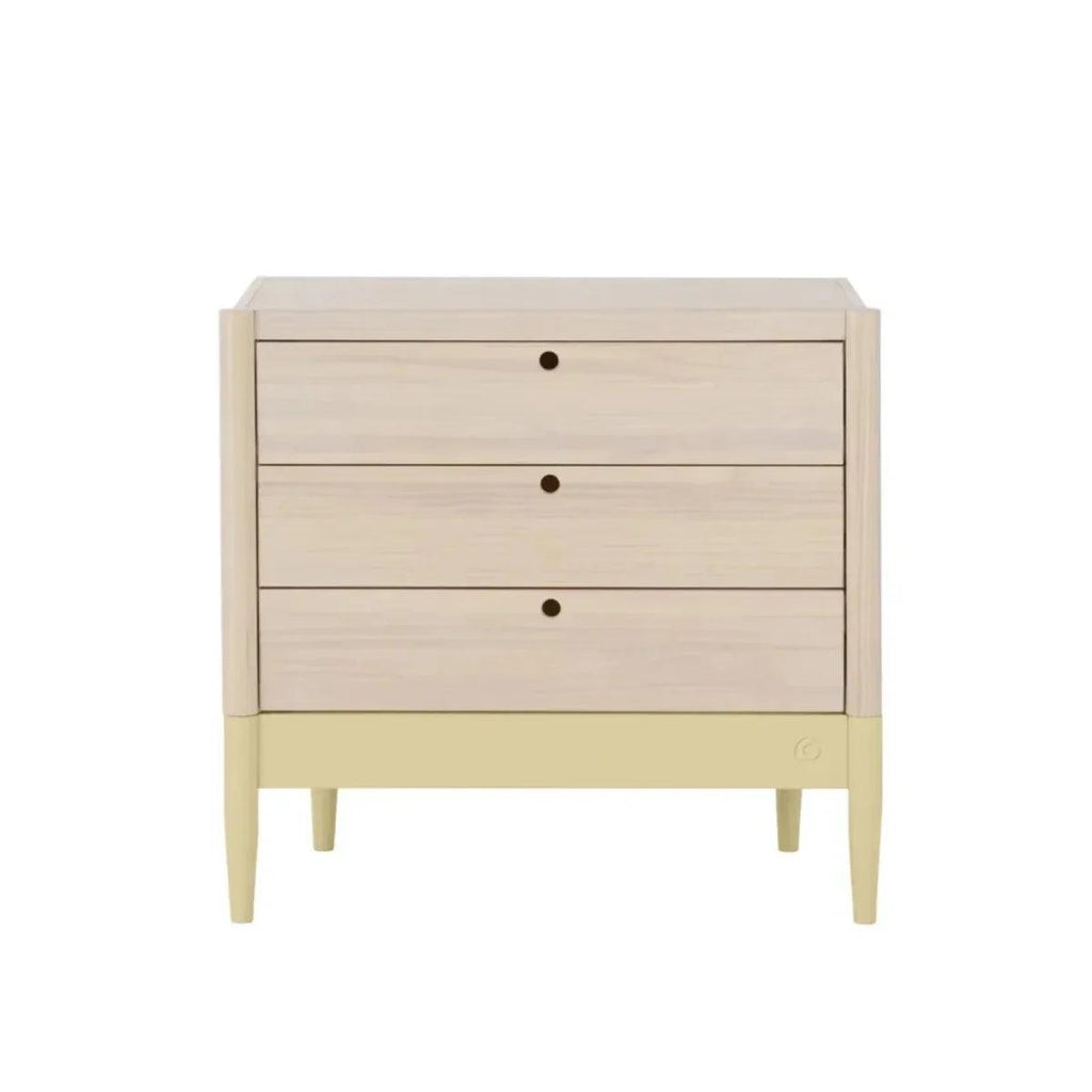 Wood baby dresser with three drawers and centered round knobs, pale yellow lower panel