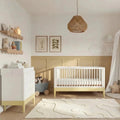 White baby cot bed with primrose yellow rail and light bedding