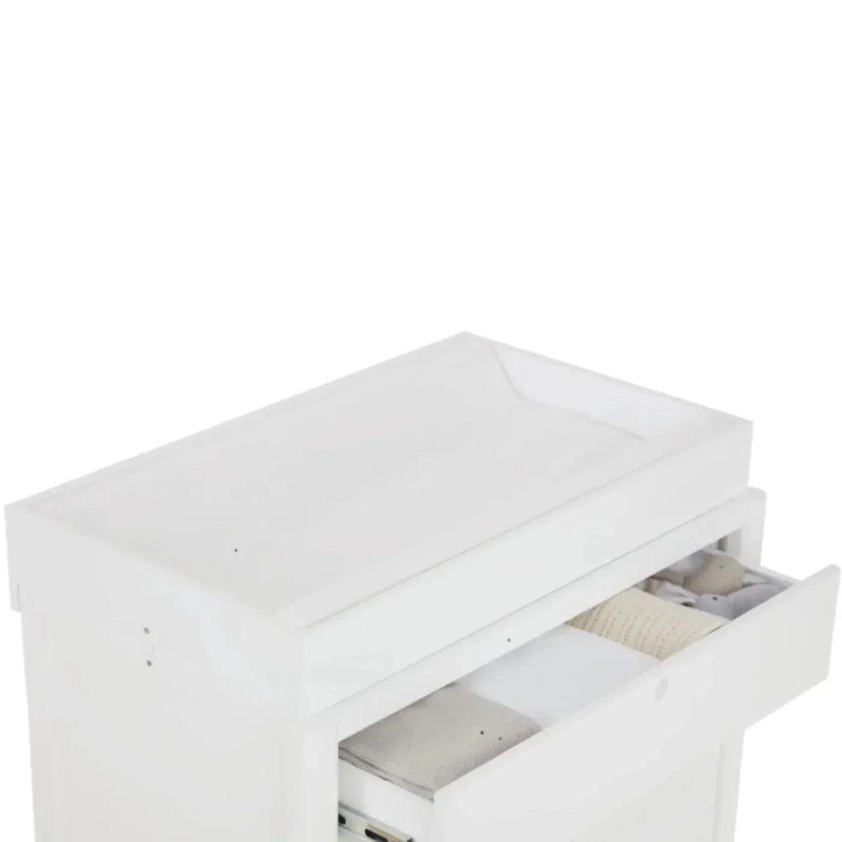 White baby changing dresser with padded top and open storage space with folded linens