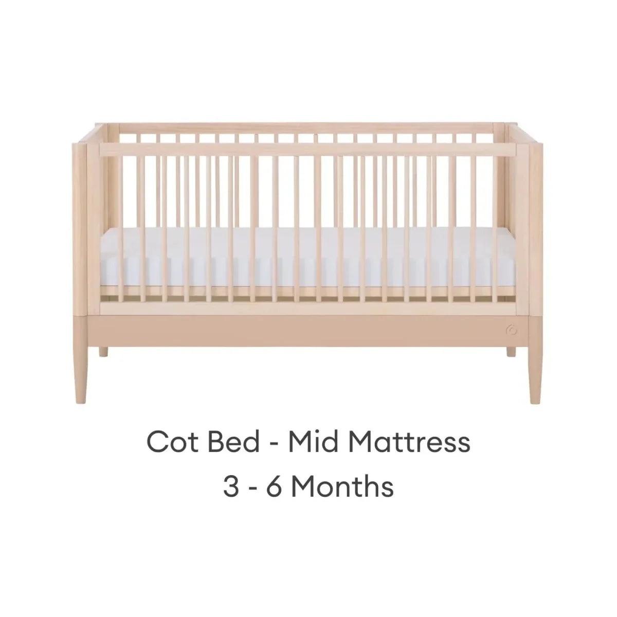 Light wood cot bed with mid mattress setting, front view
