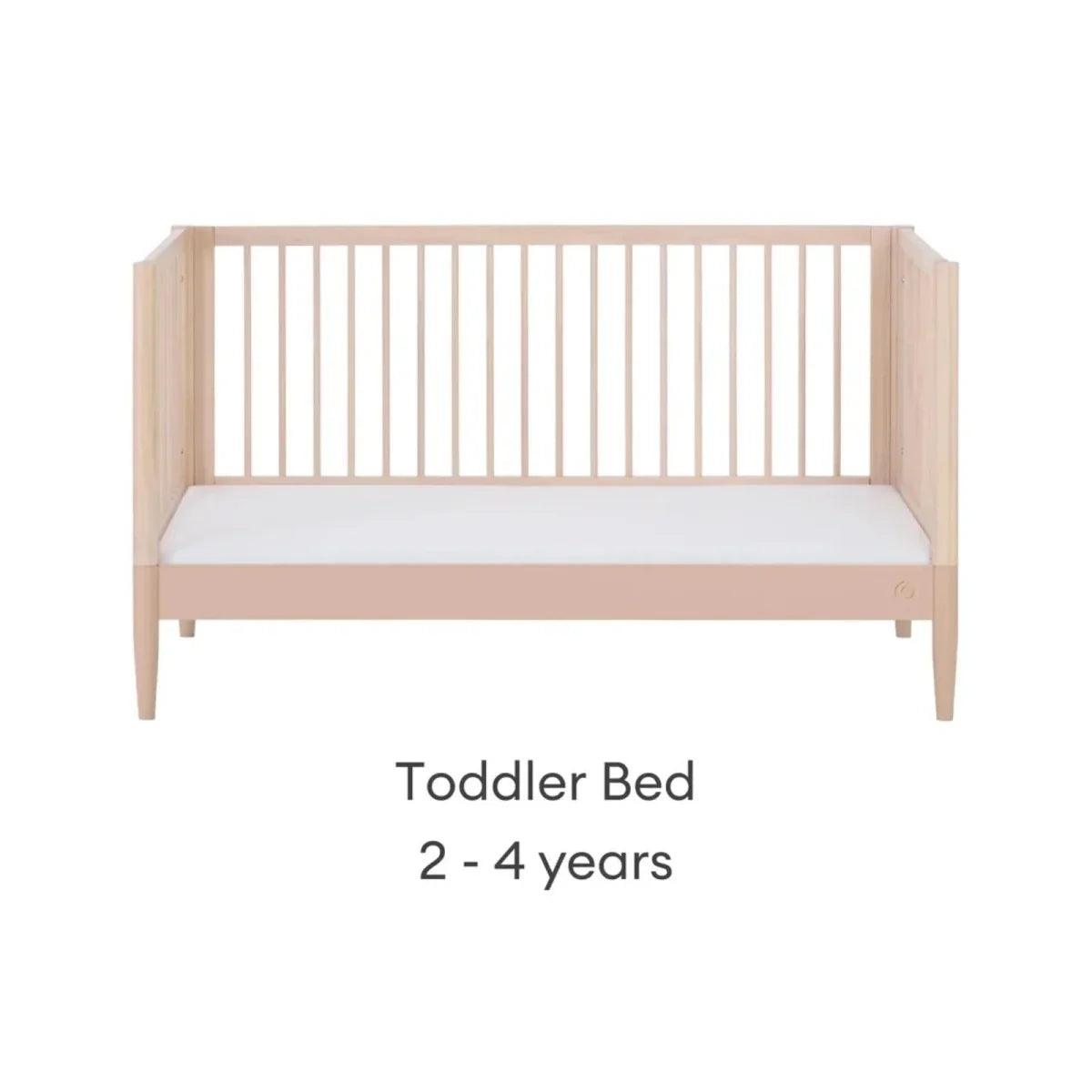 Light wood toddler bed with mattress, front view