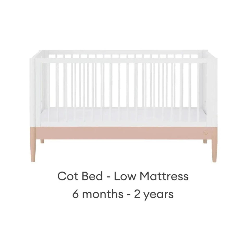 White cot bed with blush mattress band in low position