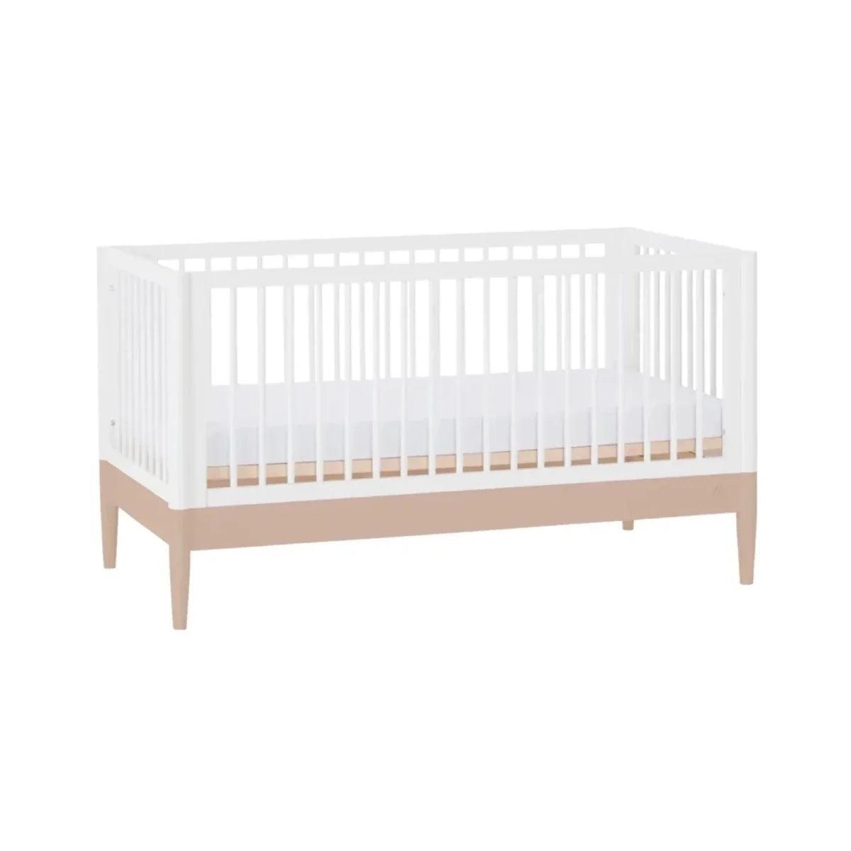 White baby crib with slatted sides and beige legs